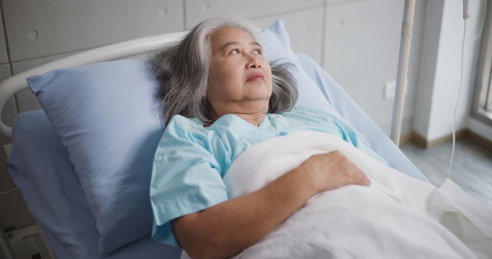 Free Image of Portrait of Elderly female patient undergoing treatment lying on a hospital bed. 