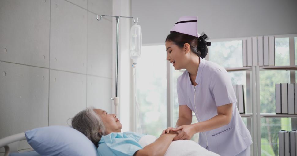 Free Image of Portrait of Young nurse comforting a senior female patient lying in hospital bed,Caregiver and Lifestyle concept 