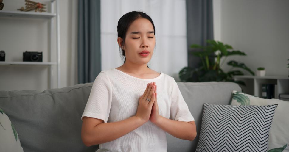 Free Image of Selective focus, Young attractive woman sitting resting on sofa with eyes closed do meditation in the living room at home, deep relaxation practice, breathing fresh air 