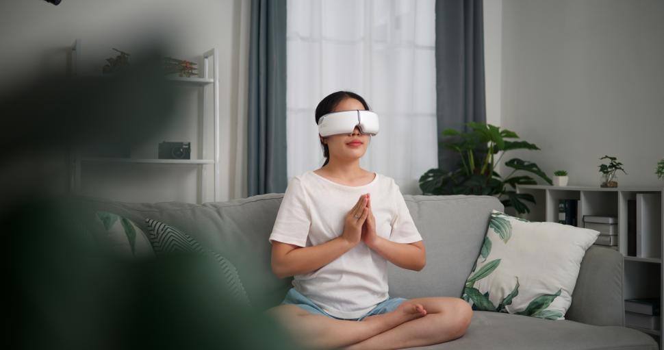Free Image of Selective focus, Relaxed young woman wear VR goggles meditating enjoying rest on sofa in living room at home, breathing fresh air, 