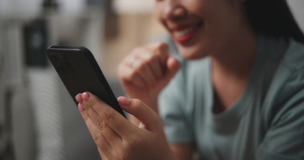 Free Image of Selective focus, Hand of young woman sitting on sofa use mobile phone 