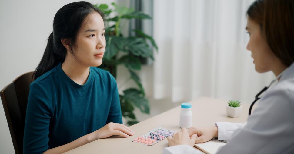 Free Image of Selective focus, Asian doctor explaining how to take medicine to young female patient in clinic office, Health and medicine consultant, Conversation about healthcare 
