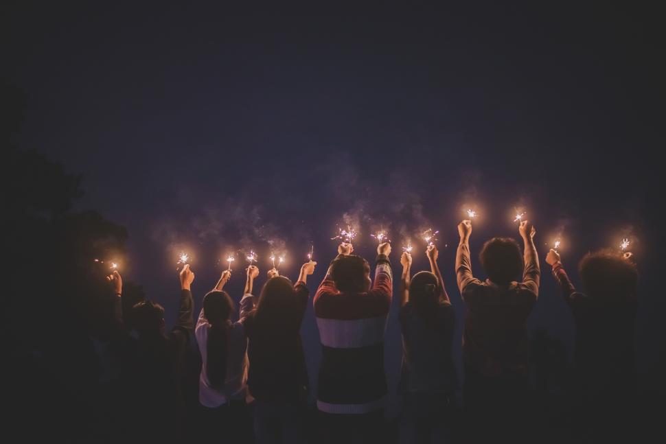 Free Image of Group of young friends enjoy with burning sparkler in hands together 