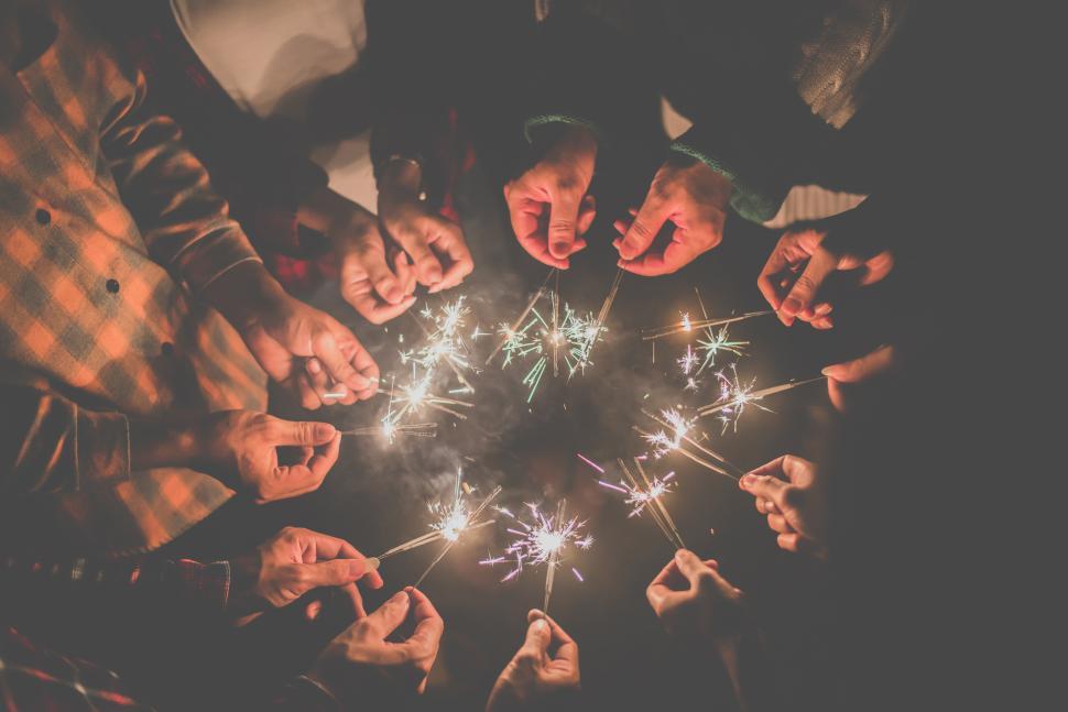 Free Image of Group of young friends enjoy with burning sparkler in hands together 