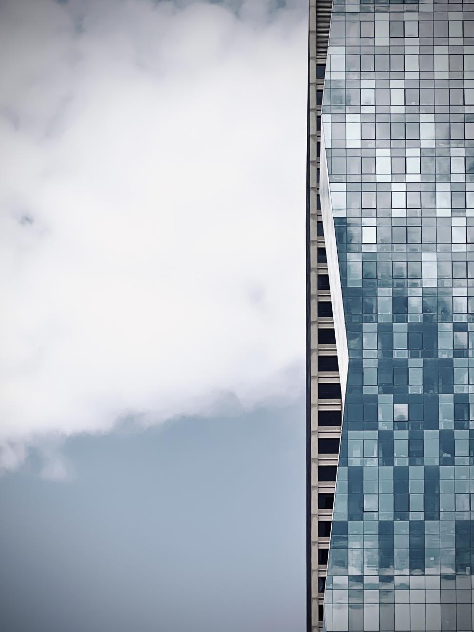 Free Image of Angles of modern Wabash Building skyscraper in Chicago reveal building behind, reflecting clouds on a clear day near downtown 