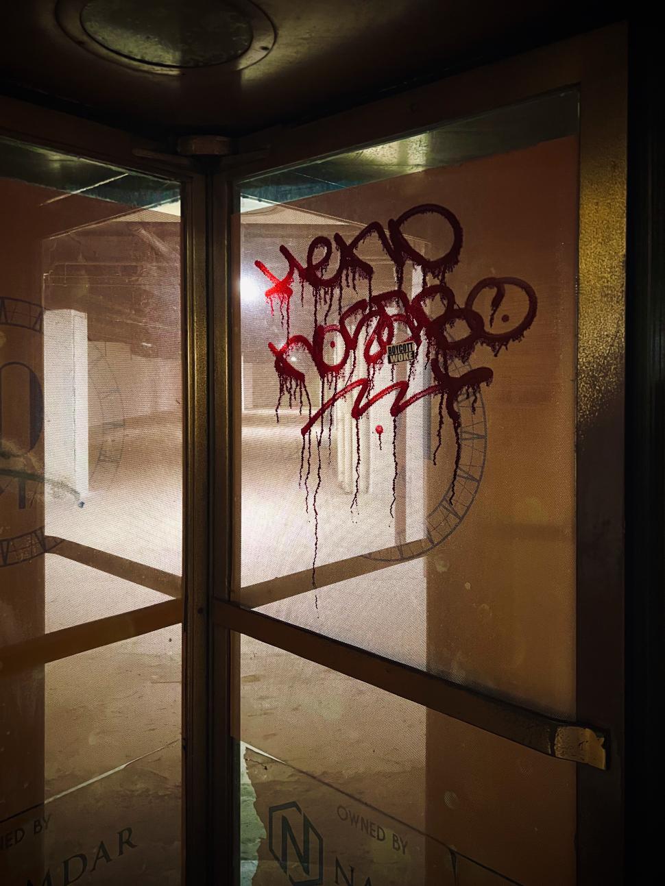 Free Image of Graffiti on revolving door creates a striking contrast in an abandoned building 