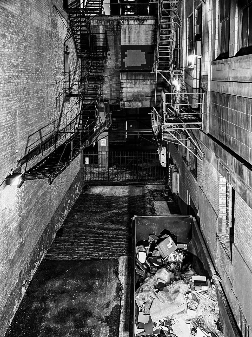Free Image of Exploring a dark alley in Chicago filled with urban decay and forgotten debris at night 