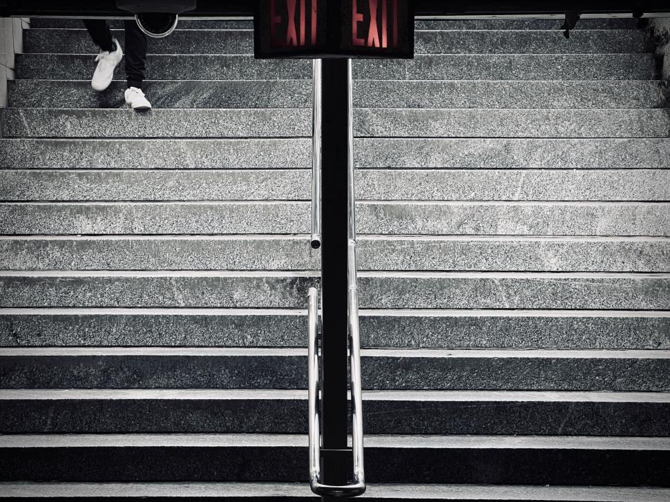 Free Image of Stairs leading to an underground subway station, with just the feet of a traveler visible. 