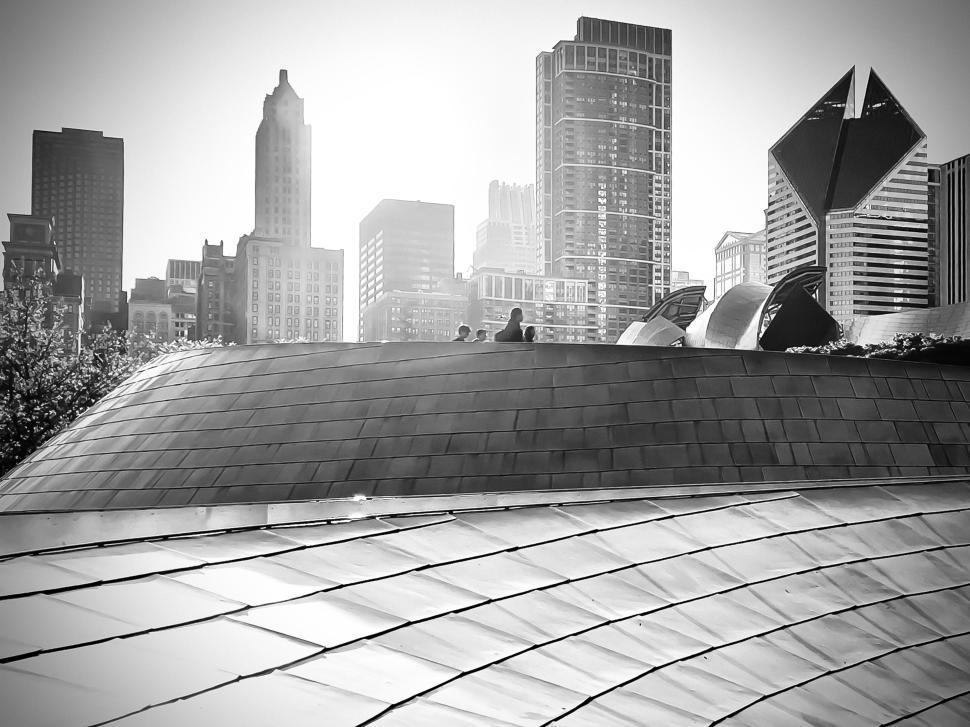 Free Image of Exploring Frank Gehry s BP Pedestrian Bridge in Chicago with skyline views at dusk 
