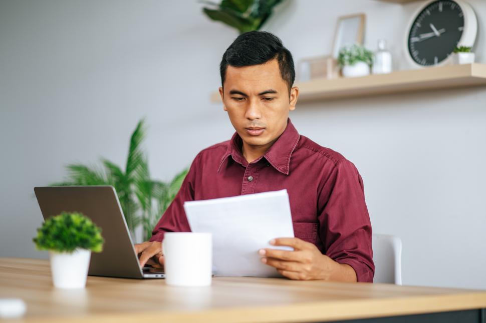Free Image of A man works in an office with a laptop. 
