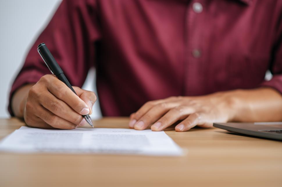 Free Image of Male employee signing documents to approve work 