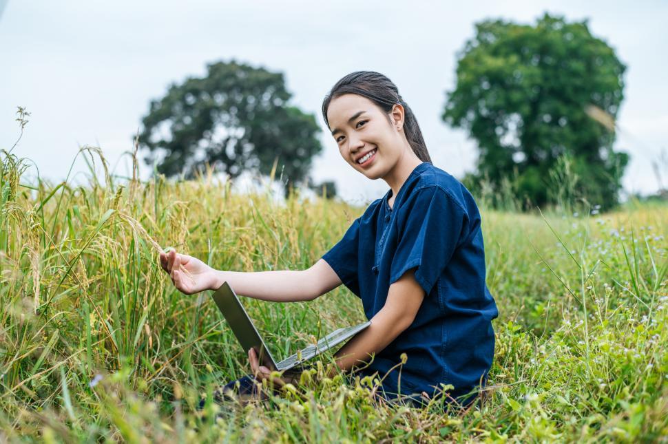 Free Image of Young smart farmer woman use laptop in rice field 