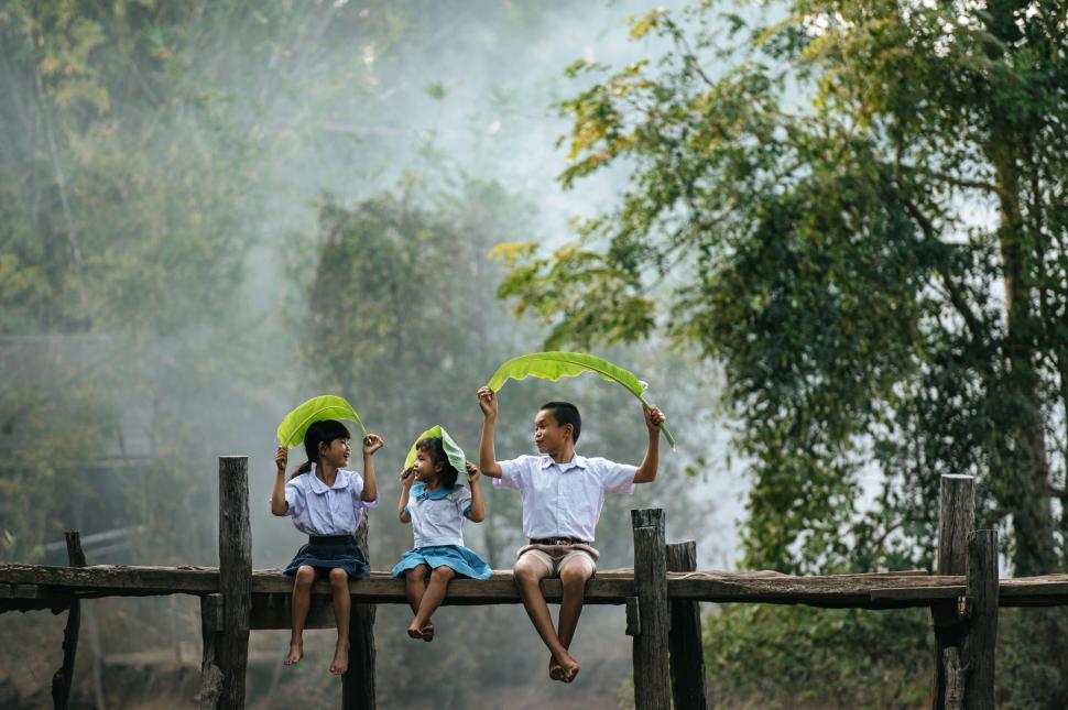 Free Image of Asian children sitting and play with banana leaves 