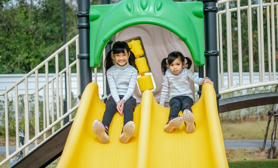 Free Image of Two girls play slides in the playground. 
