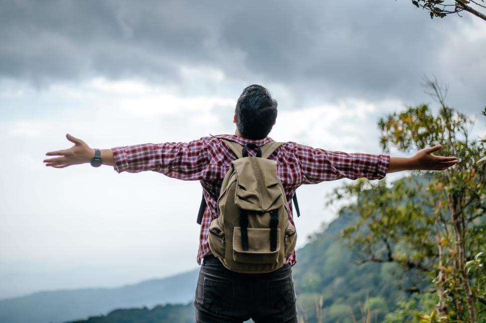 Free Image of Young trekking man standing on rocky mountain peak 