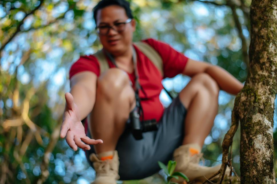 Free Image of Young hiker man hold someone hand help to climb up 