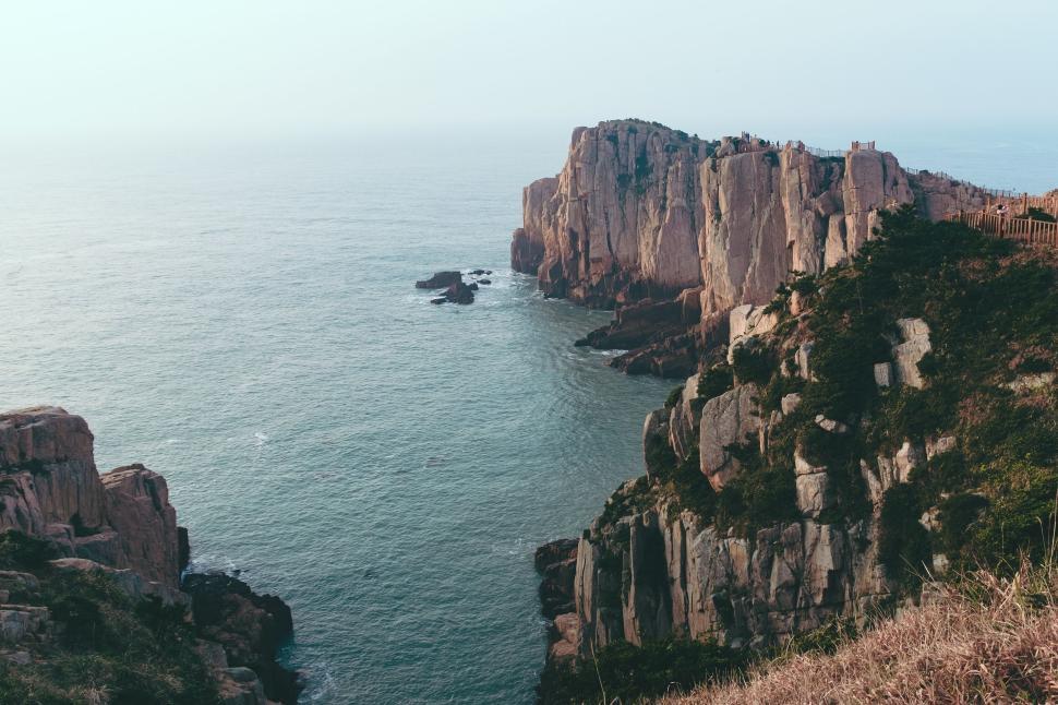 Free Image of Majestic coastal cliffs with ocean waves crashing below 