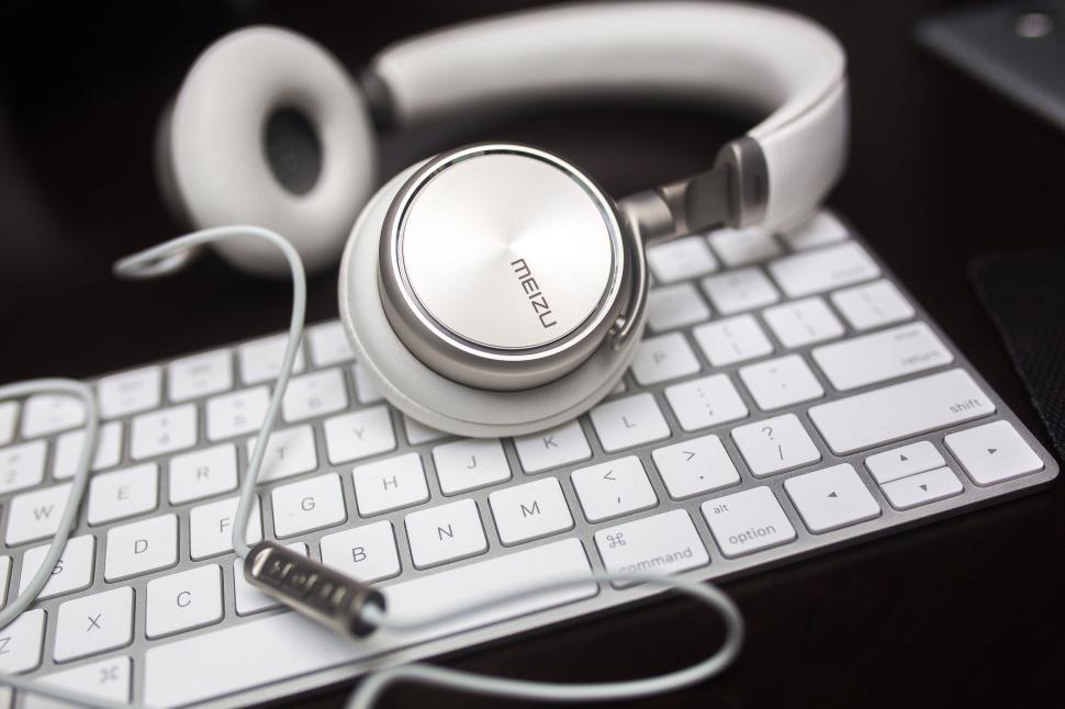 Free Image of White headphones on a keyboard, work audio setup 