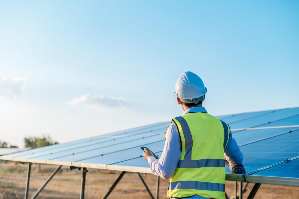 Free Image of Young engineer use smartphone while working at solar farm 