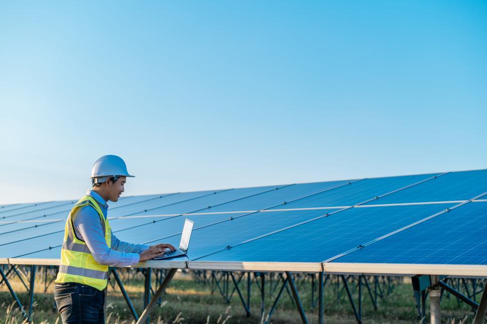 Free Image of Young technician man working on laptop in solar farm 