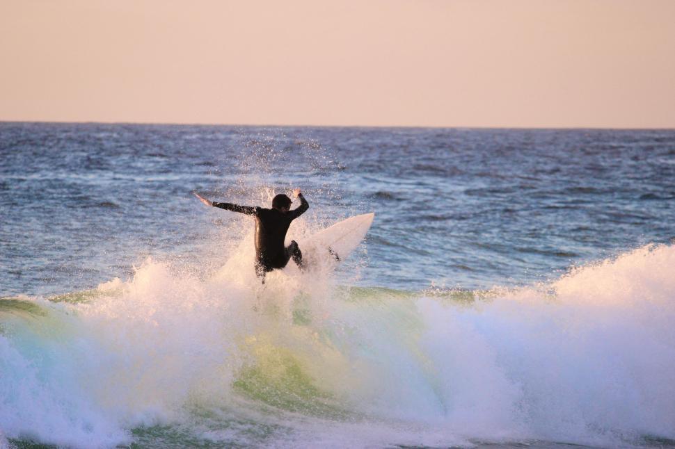 Free Image of Surfer mastering the waves at sunrise impressive image. 
