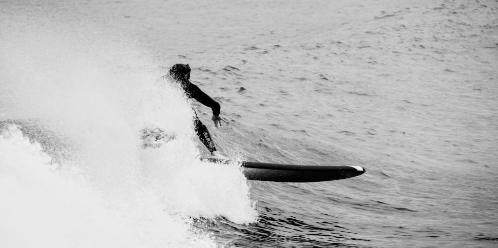 Free Image of Surfer catching a wave mid-action in monochrome style. 