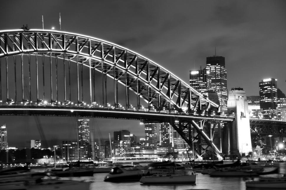 Free Image of Sydney Harbour Bridge illuminated at night with skyline. 