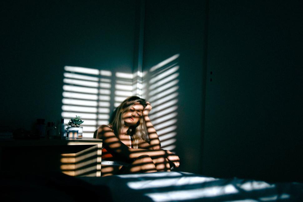 Free Image of Person sitting in dim room with striped light patterns 