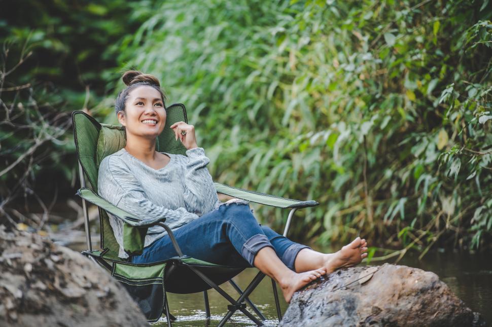Free Image of Young woman sitting on camping chair in stream for relax 