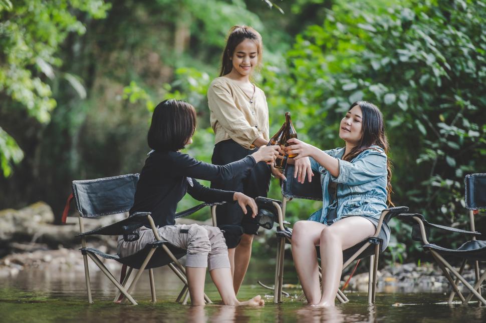 Free Image of Group of women drink beer and soaked feet in stream 