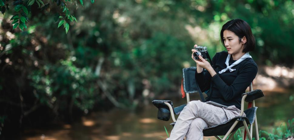 Free Image of Young pretty woman use camera taking photo in nature park 