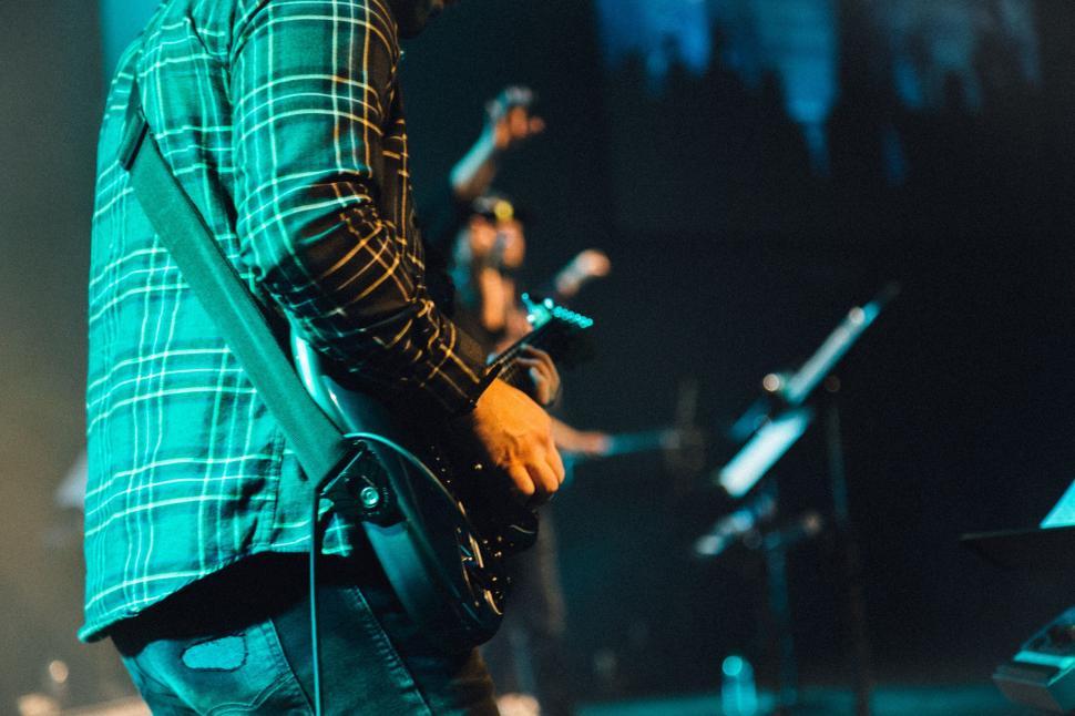 Free Image of Electric guitarist performing live on stage during concert. 