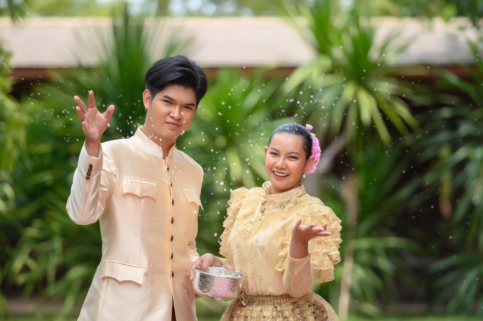 Free Image of Young couple splashing water from bowl on Songkran festival 