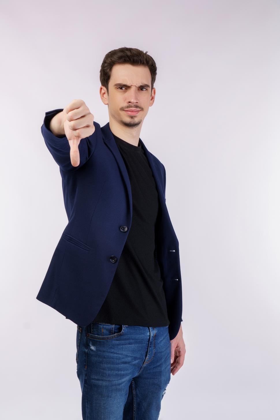 Free Image of Portrait of young businessman shows sign of dislike, looks with negative expression and disapproval on isolated background 