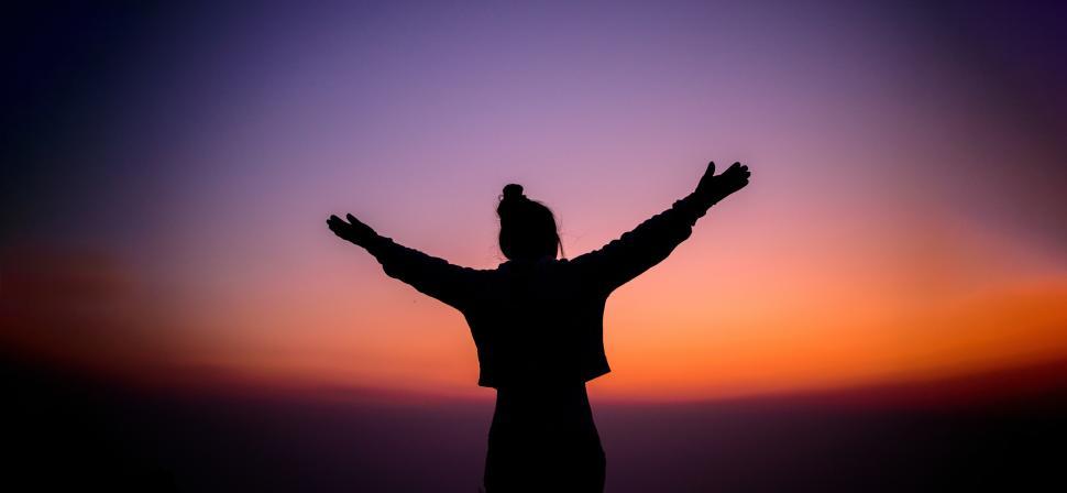Free Image of Silhouette of cheering hiking woman open arms to the sunrise stand on mountain 