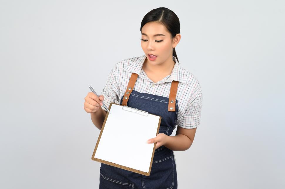 Free Image of Portrait of young asian woman in waitress uniform pose with clipboard 
