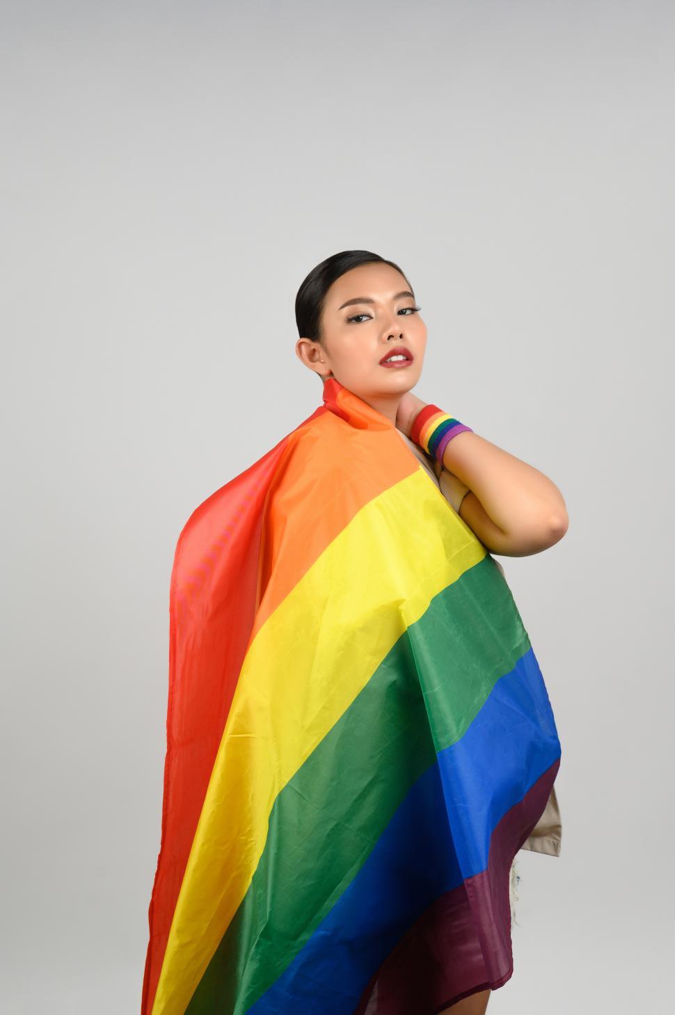 Free Image of Woman celebrates LGBTQ community wrapped in rainbow pride flag 