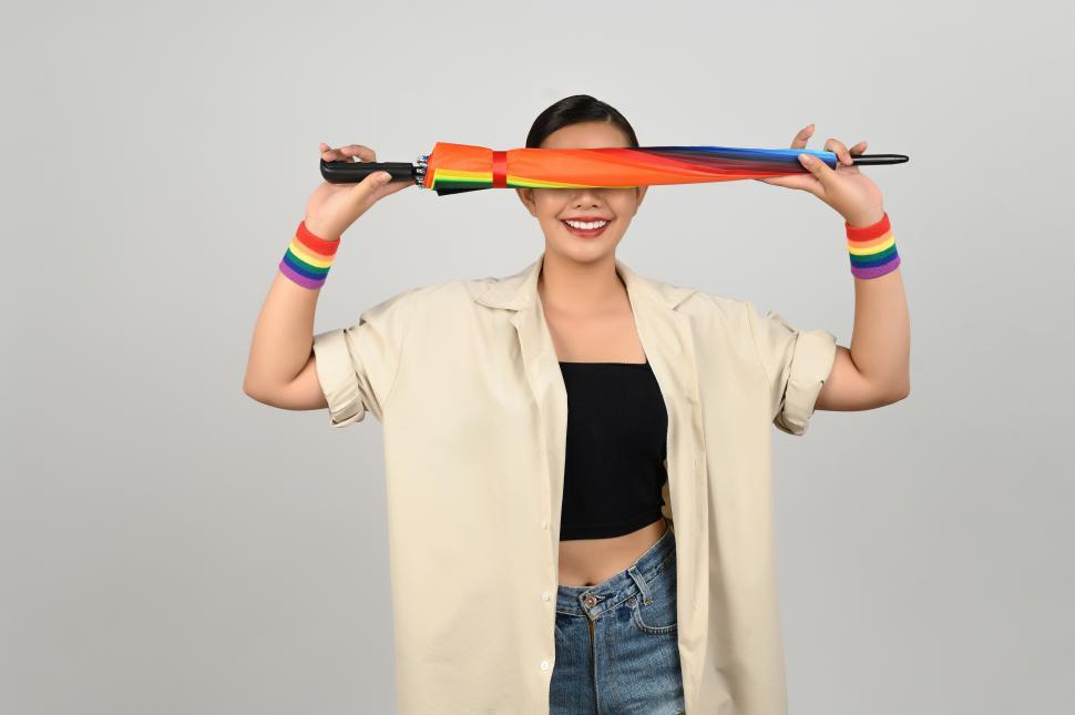 Free Image of Celebrating inclusion with a rainbow umbrella, wristbands and joyful expressions 