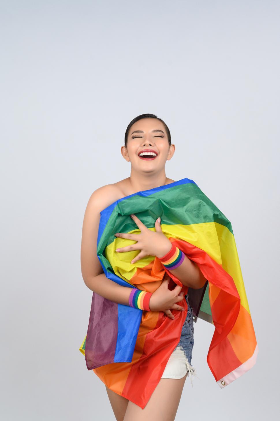 Free Image of Woman poses with crumpled gay pride flag 