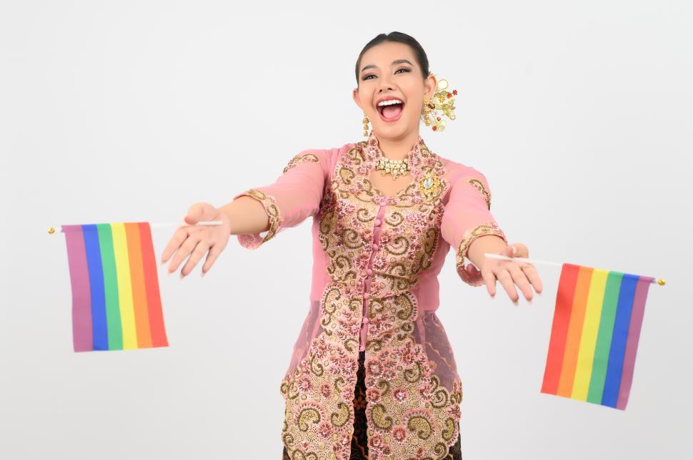 Free Image of Young beautiful woman dress up in local culture in southern region with rainbow pride flags 