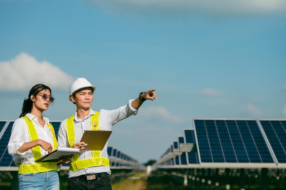 Free Image of Young Inspector Engineer man and female checking operation in solar farm 