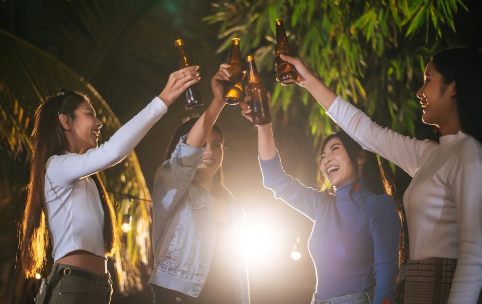 Free Image of Portrait of Happy friends having dinner party together - Young people toasting beer glasses dinner outdoor  - People, food, drink lifestyle, new year celebration concept. 