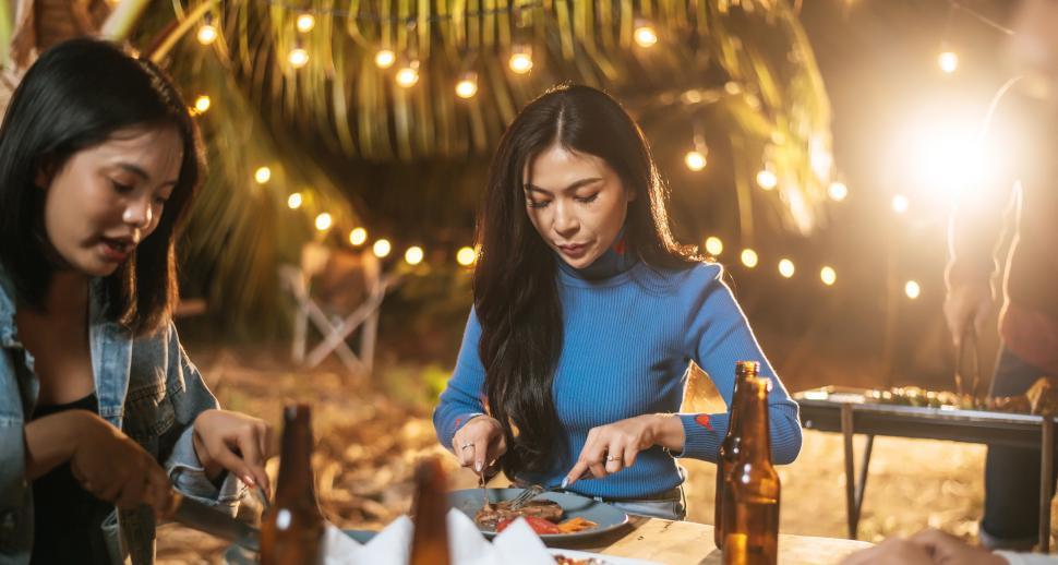Free Image of Happy friends cheering with roasted turkey dinner outdoor - Group of people having fun in new year party. People, food and drink lifestyle concept Night Party, people and celebration concept. 