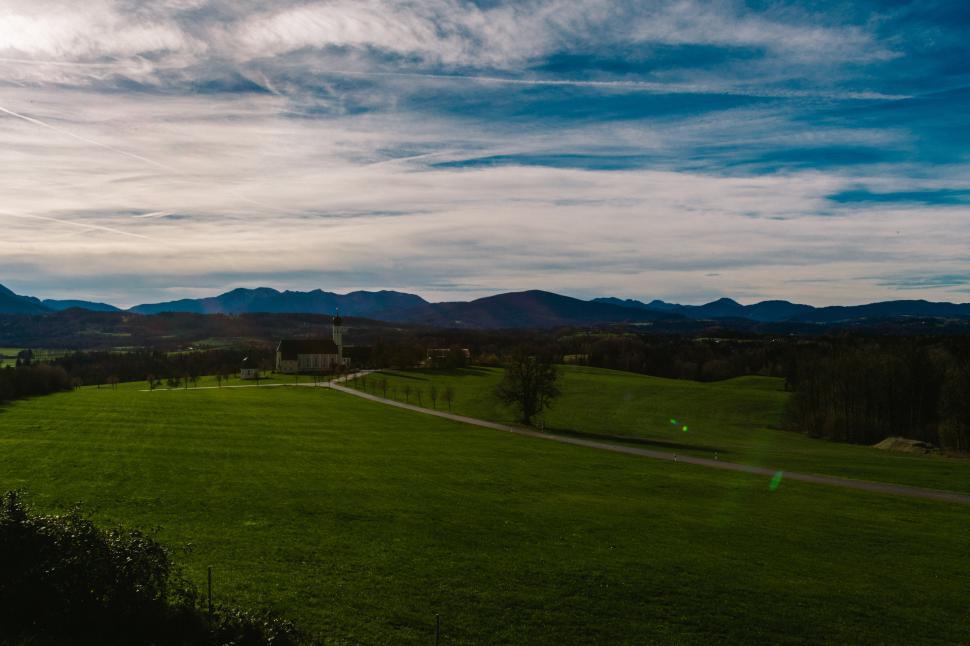 Free Image of Expansive green landscape with mountains in the distance 