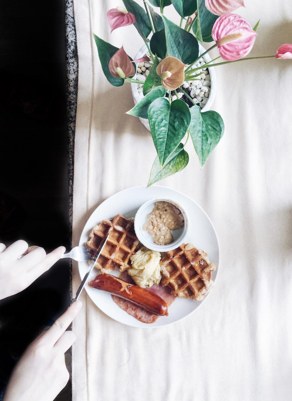Free Image of Enjoying brunch with waffles and sausages in a cozy setting 