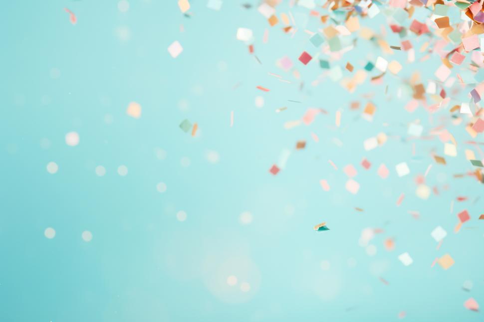 Free Image of Colorful confetti falling against a blue background 