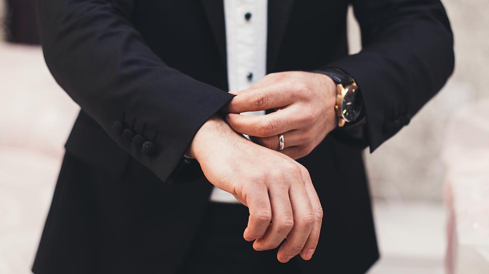 Free Image of Man adjusting cuff on formal suit before event 