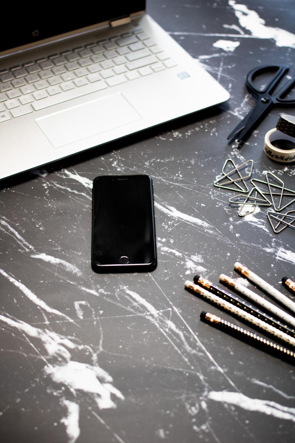 Free Image of Workspace setup with laptop and stationery on marble desk 