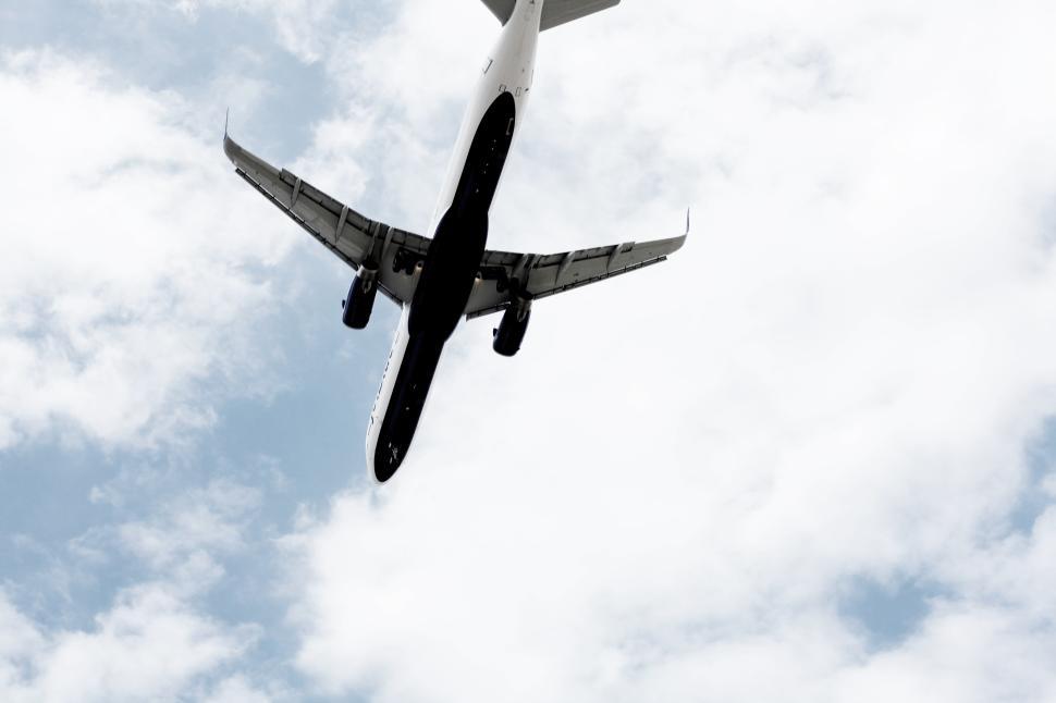 Free Image of Airplane in flight among clouds during daylight against a blue sky 