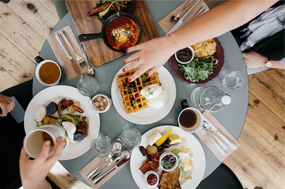 Free Image of Friends enjoying brunch with delicious dishes and drinks at cafe 